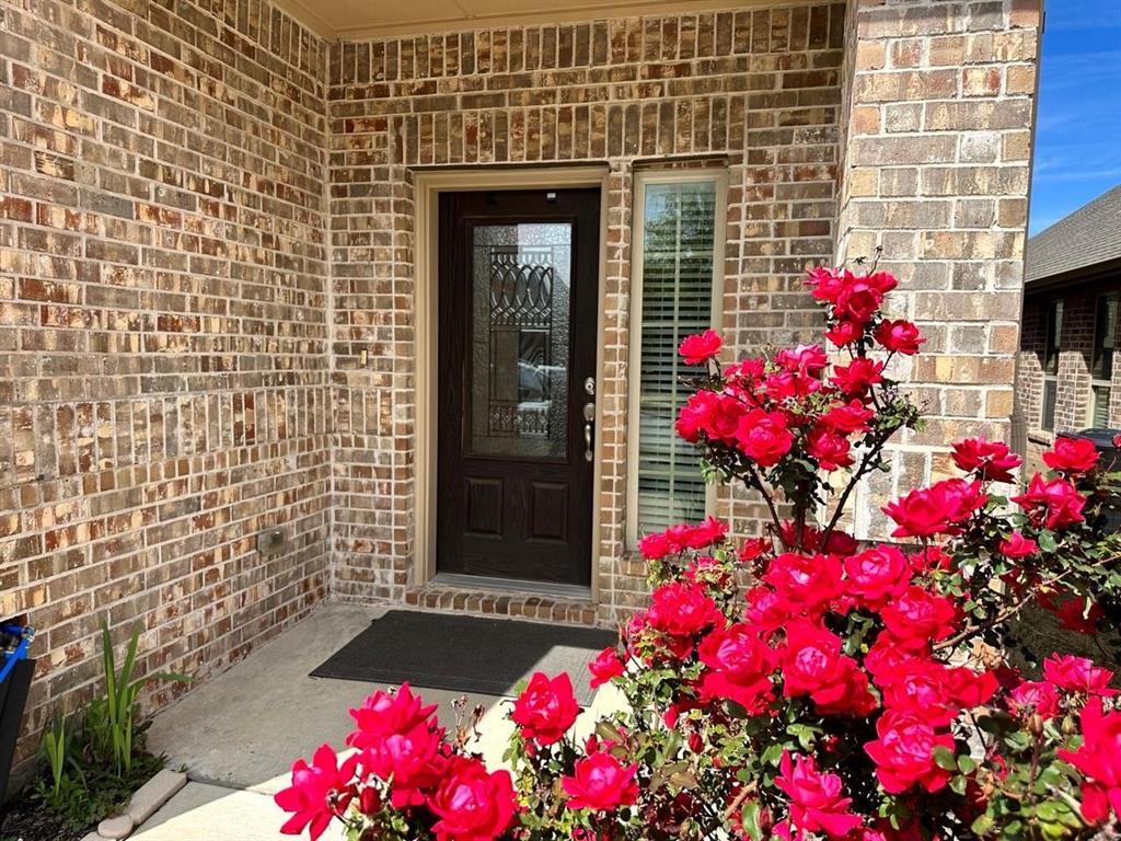 a view of front door of house and flowers