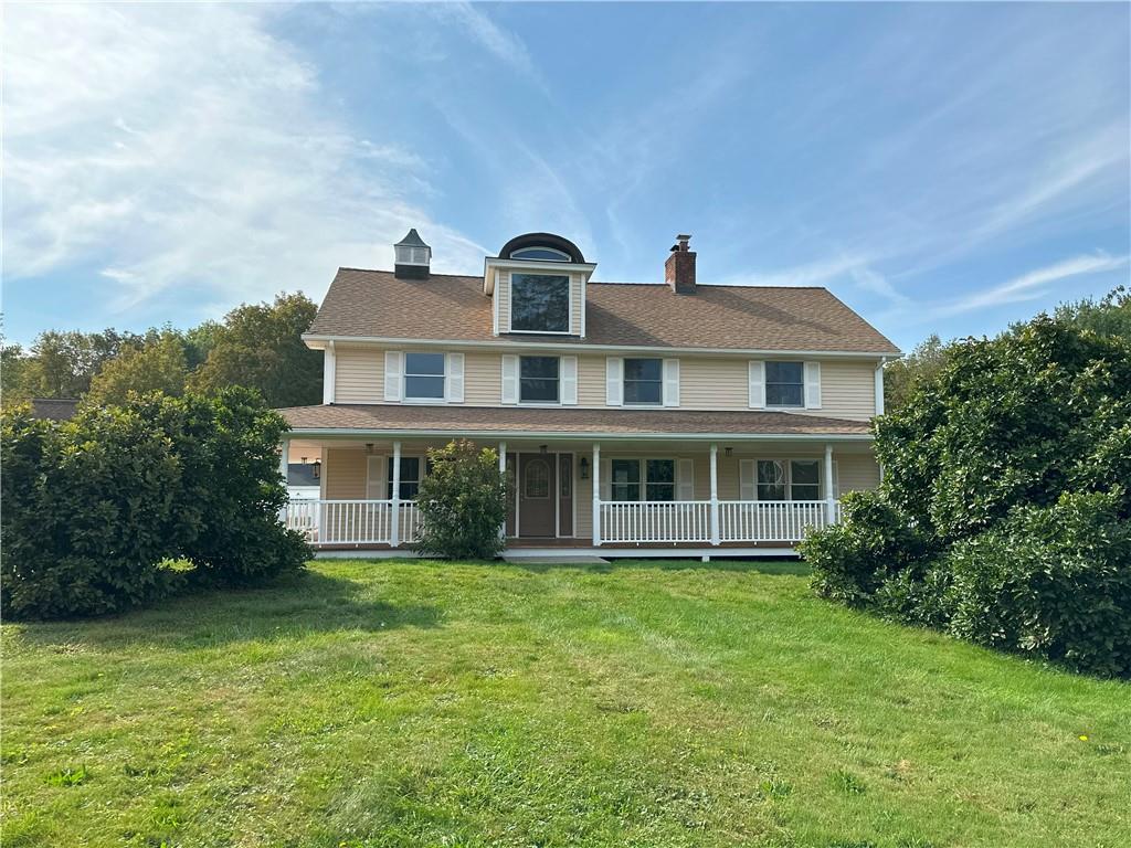 View of front of property with a front yard and a porch