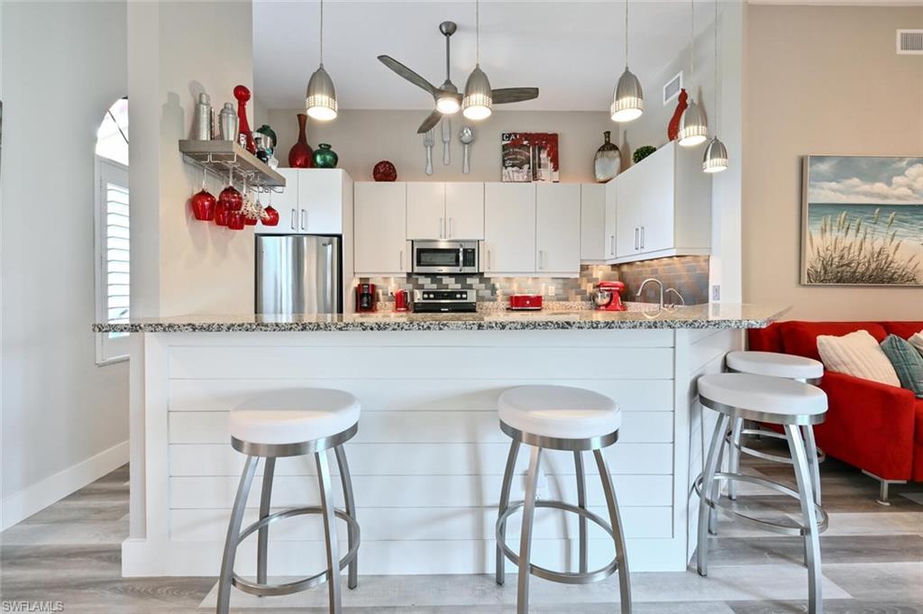 a kitchen with a dining table chairs and white cabinets