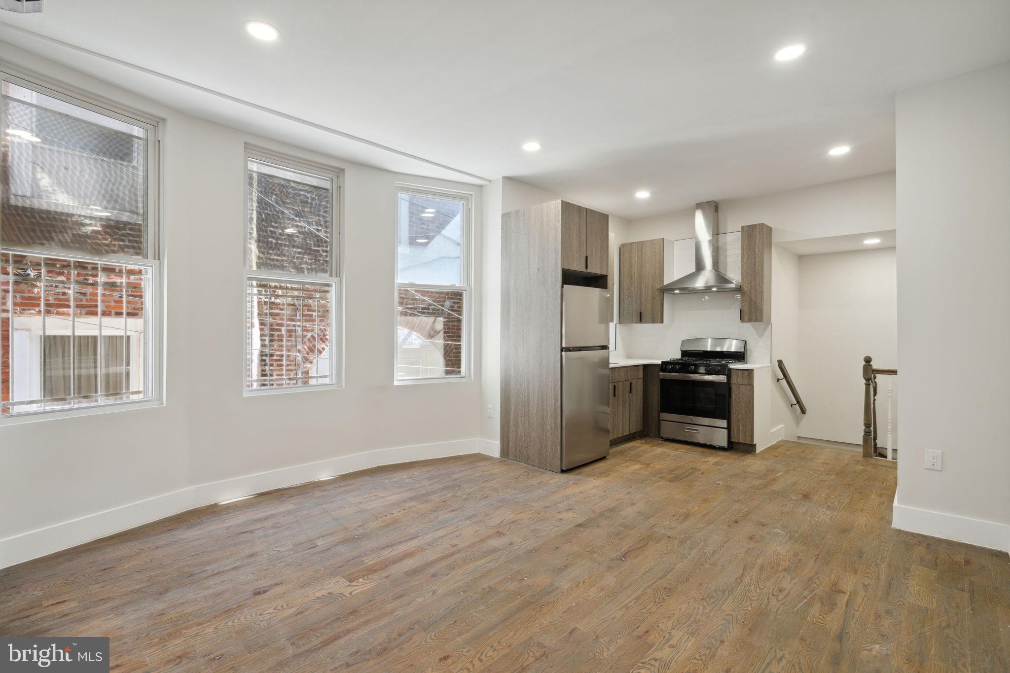 a kitchen with stainless steel appliances kitchen island granite countertop a refrigerator and a sink