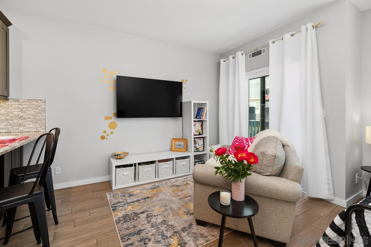 a living room with furniture potted plant and a flat screen tv