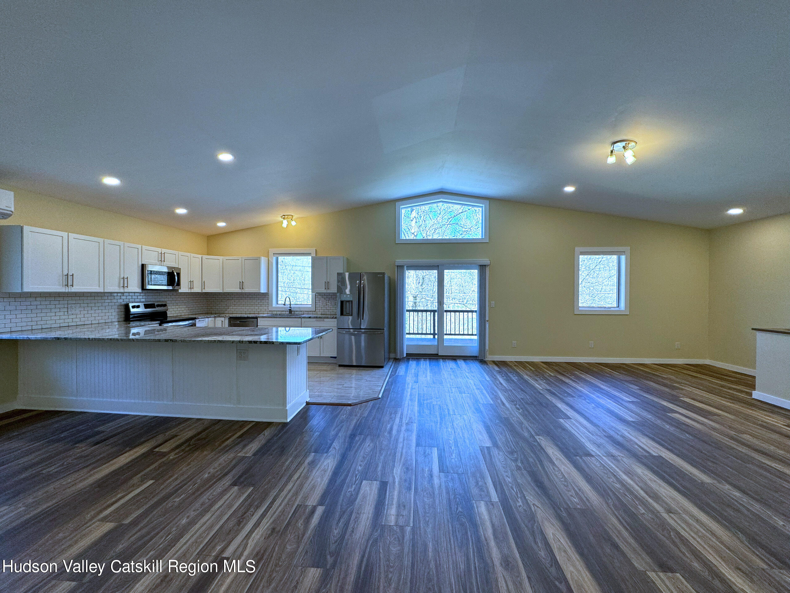 a view of kitchen with kitchen island wooden floor and center island