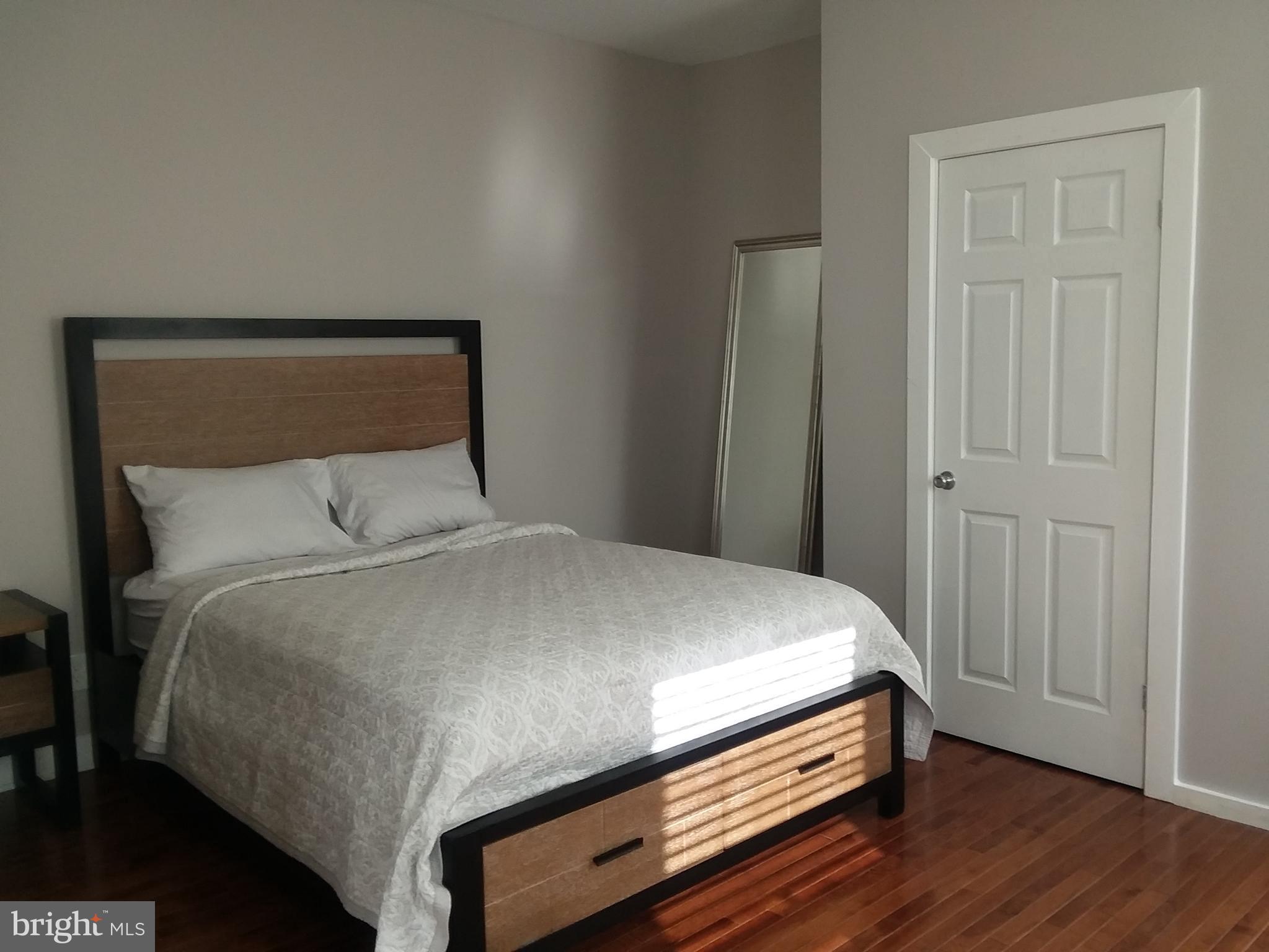 a room with a bed and wooden floor