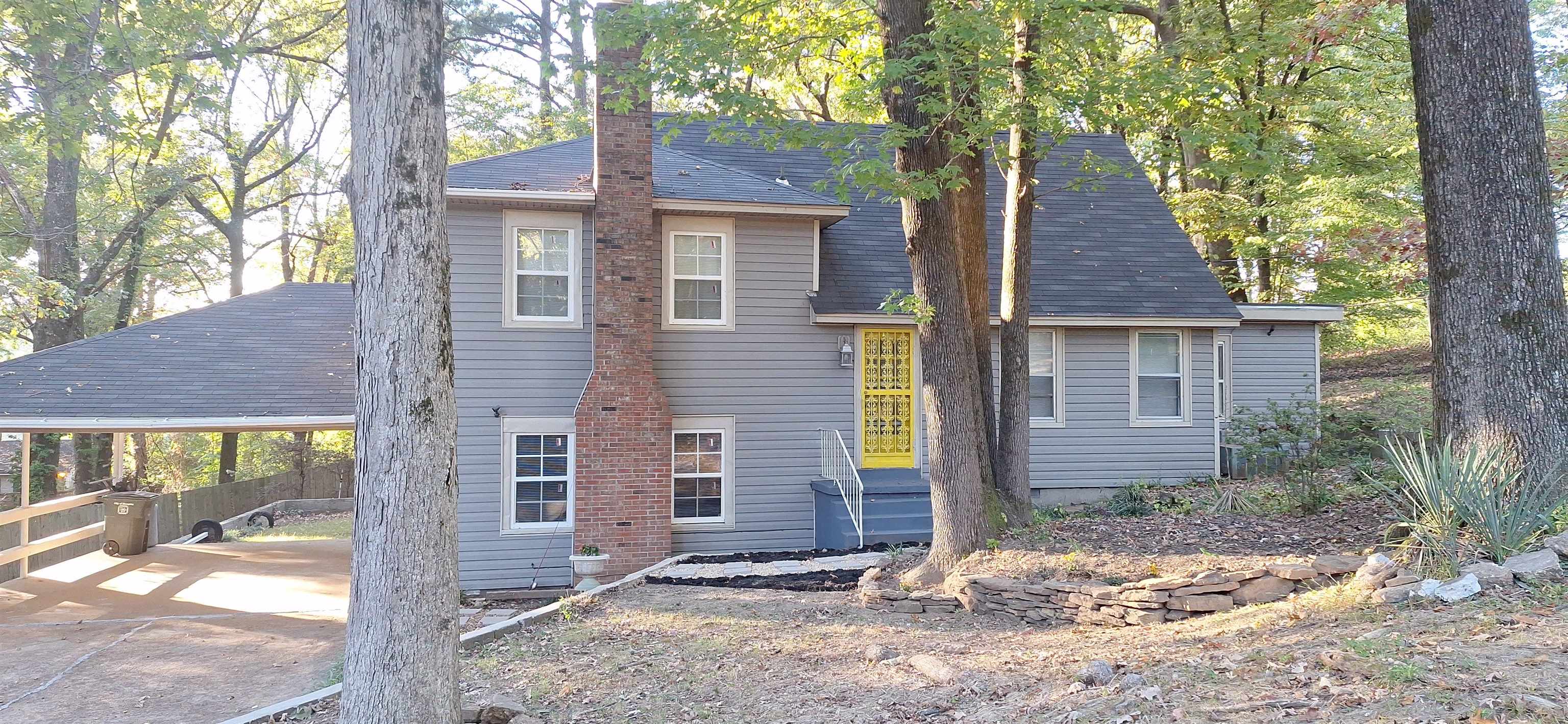 a view of a brick house with large windows and large tree