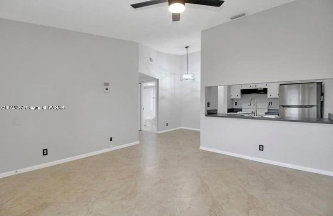 a view of kitchen with granite countertop cabinets and white appliances