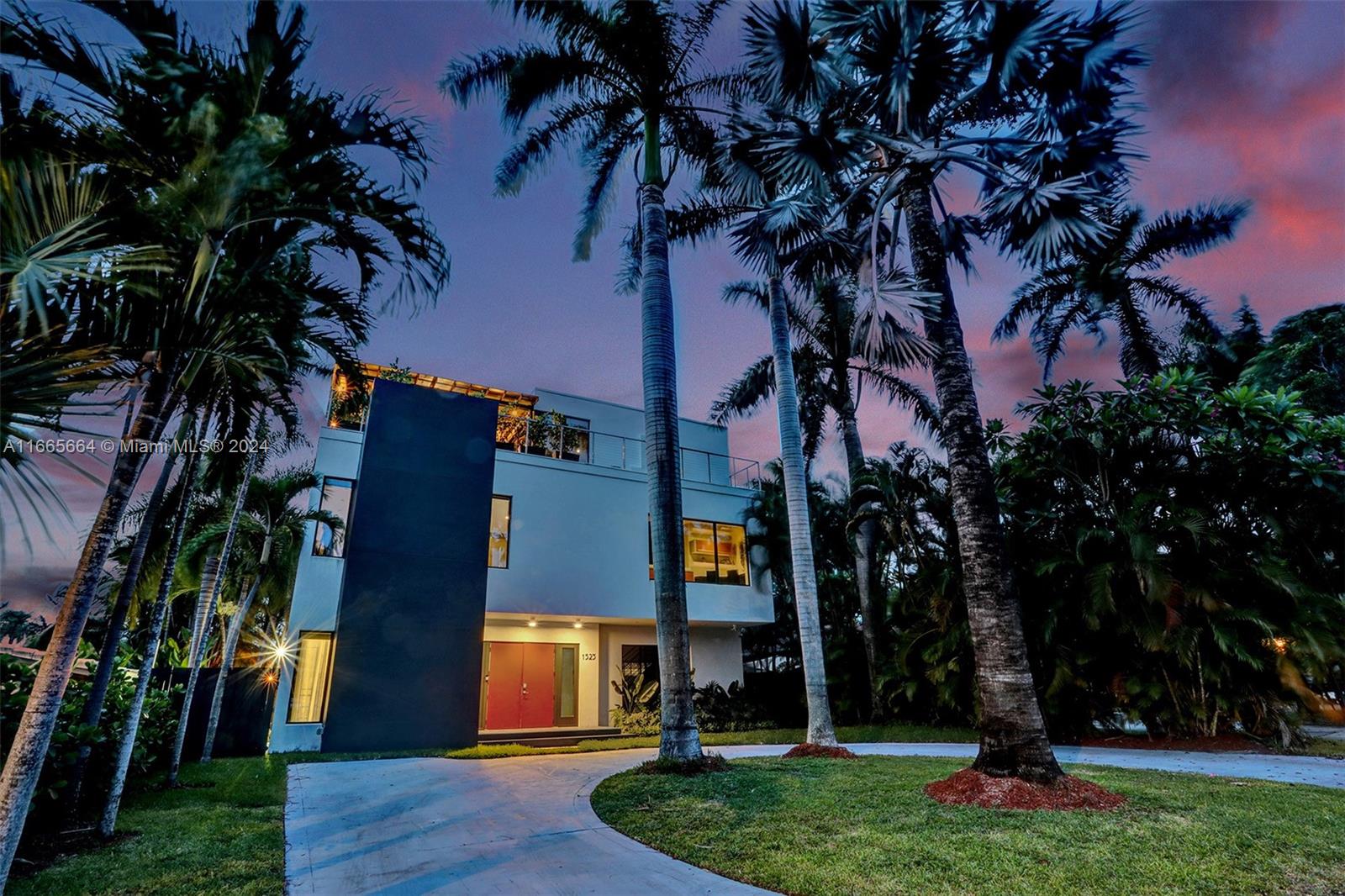 a front view of multi story residential apartment building with yard and green space