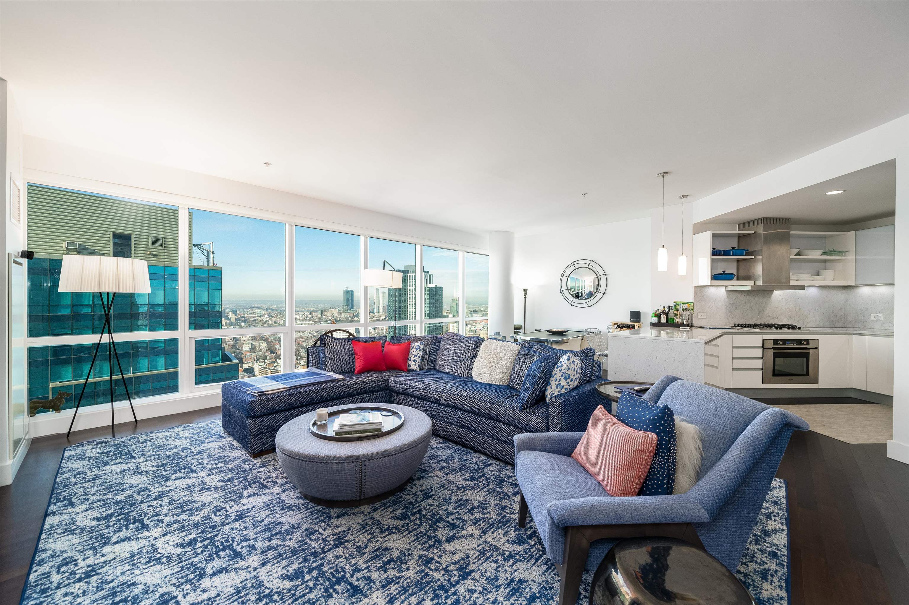 a living room with furniture a rug and a floor to ceiling window