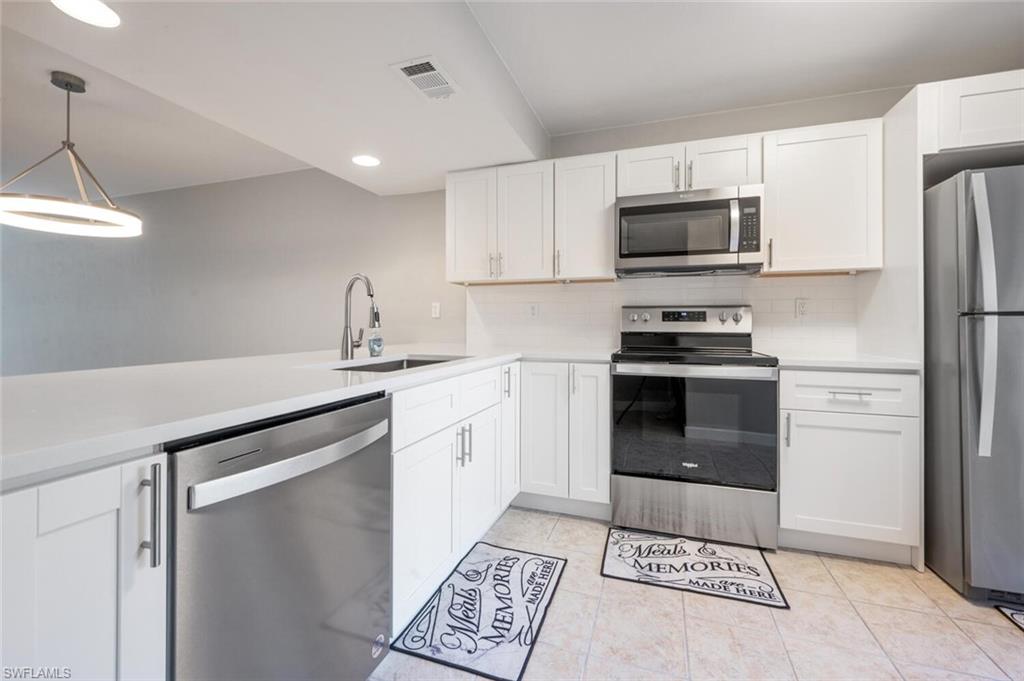 a kitchen with stainless steel appliances a refrigerator sink and microwave