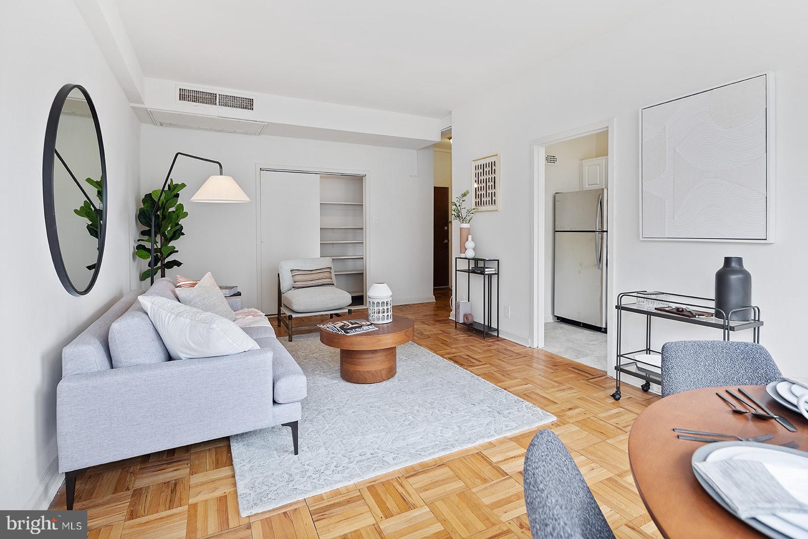 a living room with furniture a rug and white walls