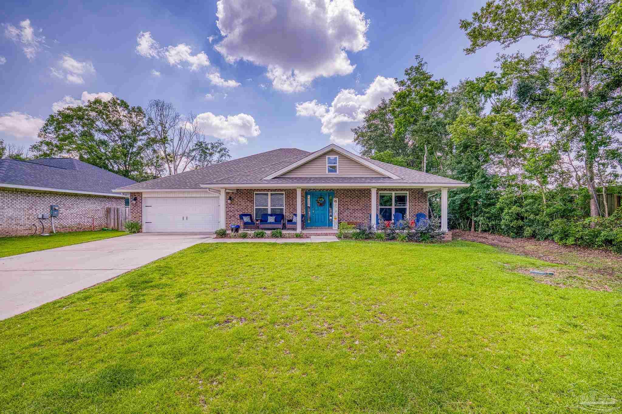 a front view of a house with yard and green space