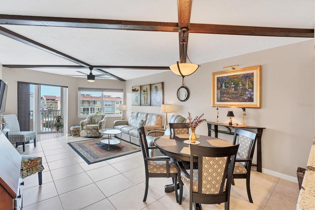 a view of a dining room and livingroom with furniture wooden floor a rug and a chandelier