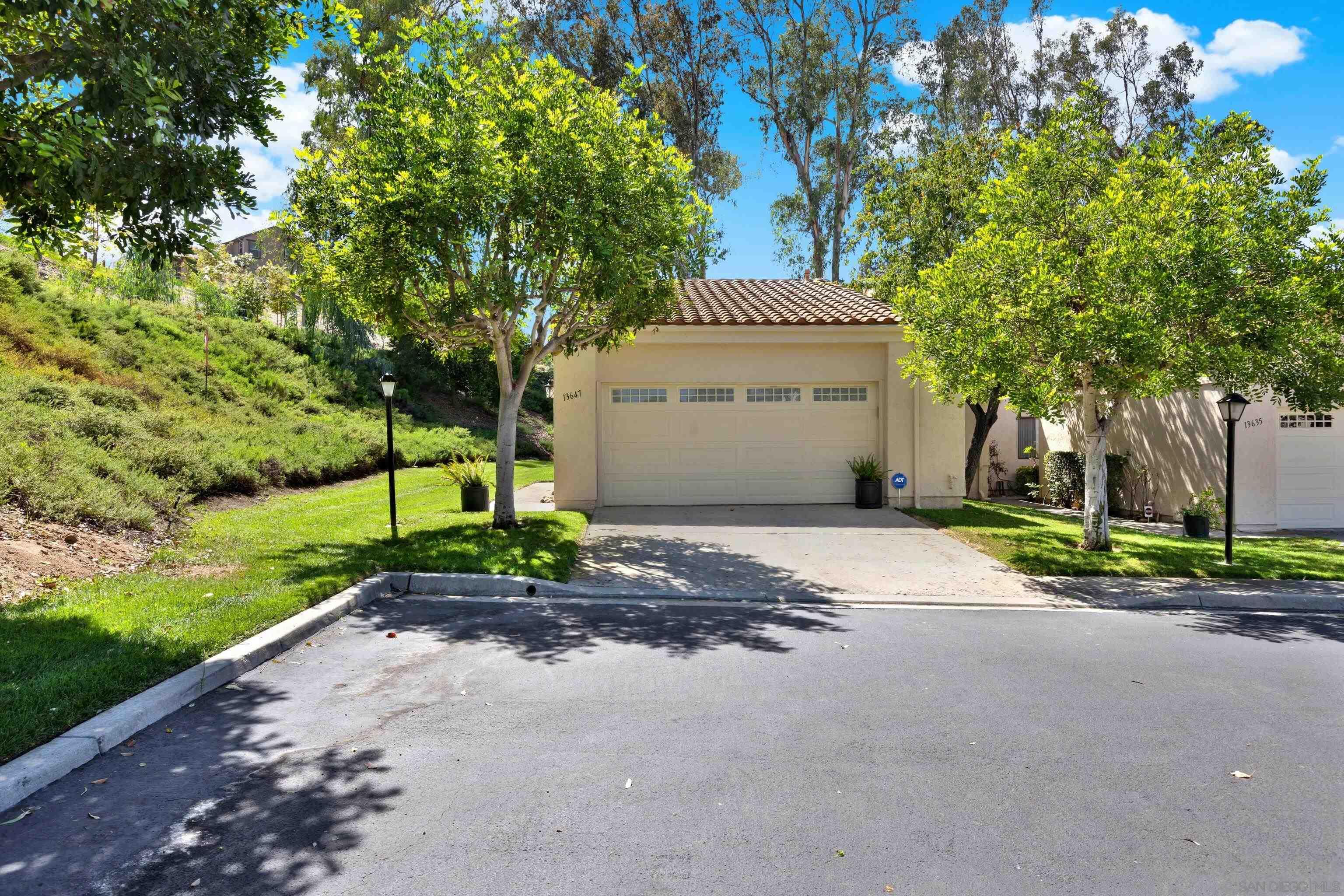 a view of a house with a small yard and palm trees