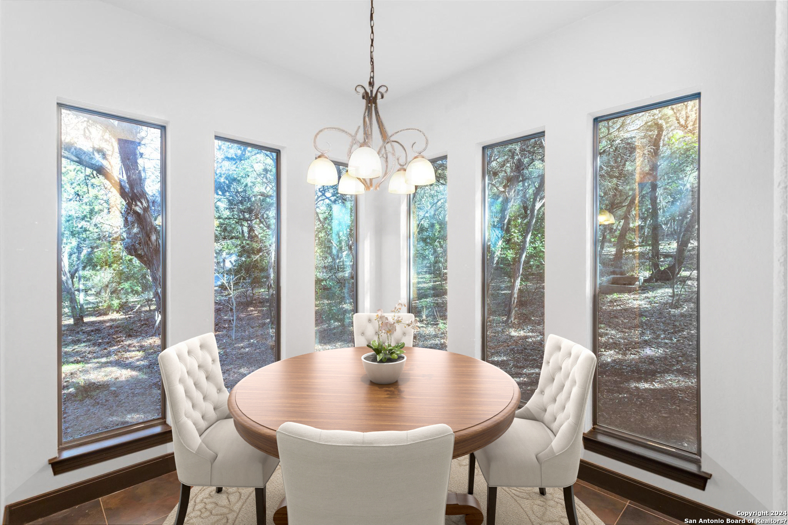 a dining room with furniture large windows and wooden floor