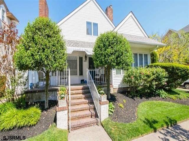 a front view of a house with a yard and potted plants