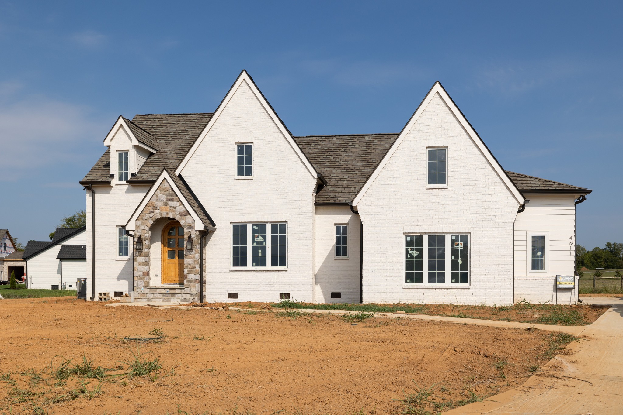 Beautiful Custom Built English Cottage Look Home with Custom flagstone archway leading to an elegant 8 ft front door made out of knotty-alderwood. Shingles are upgraded Camelot 2 designer artisan-crafted slate-like look.