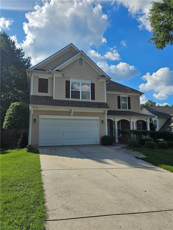 a front view of a house with a yard and garage