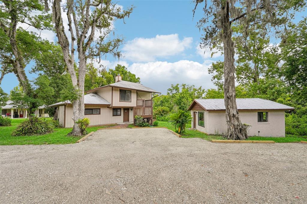 a front view of house with yard and trees around