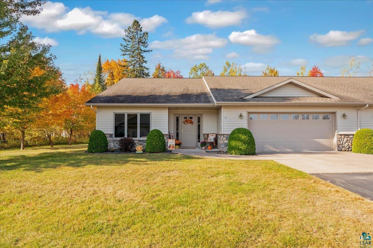 Single story home featuring a garage and a front lawn