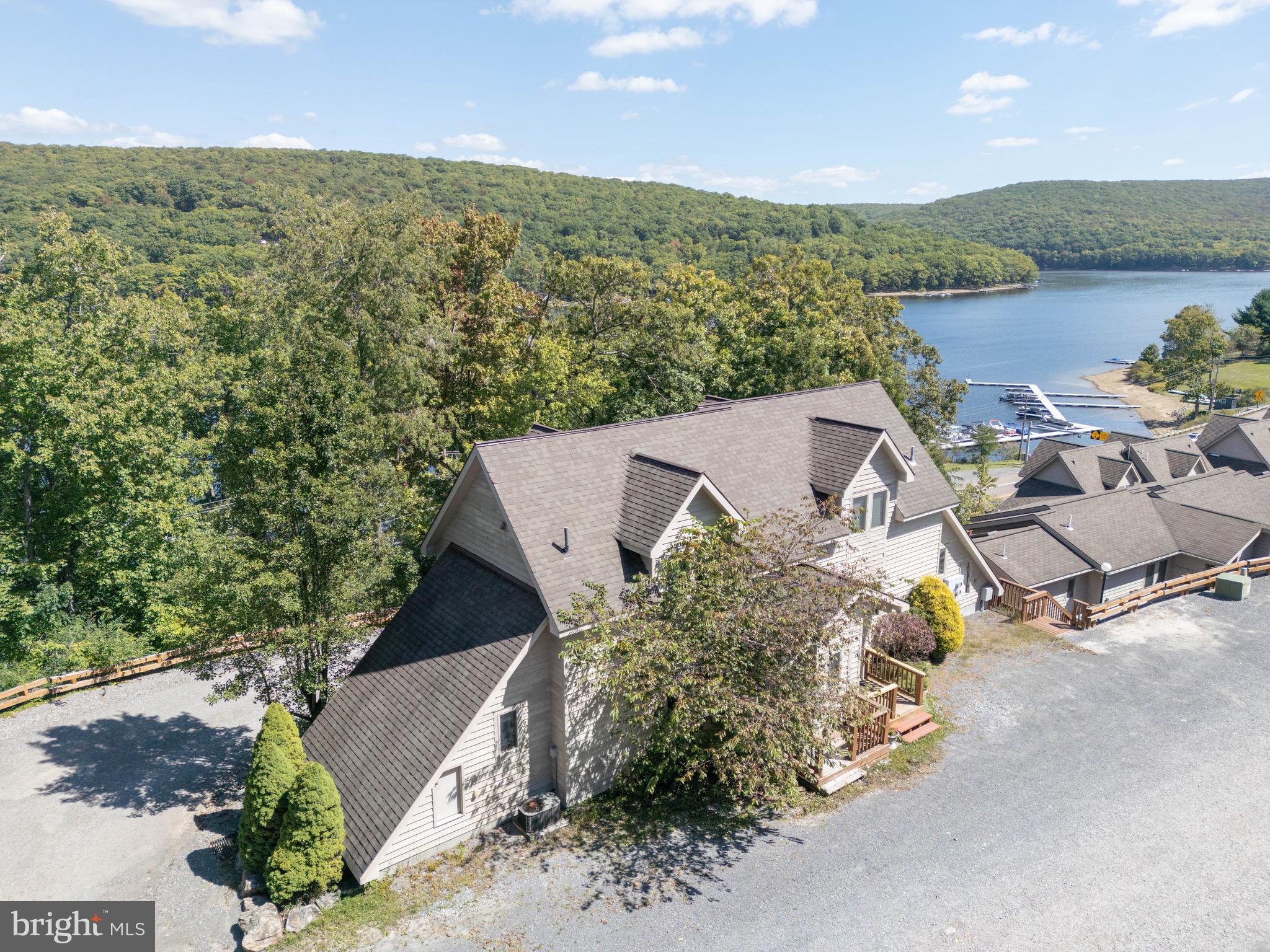 an aerial view of a house with a garden and lake view