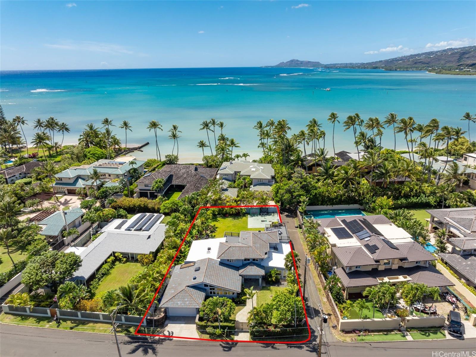 an aerial view of a city with lots of residential buildings ocean and mountain view in back