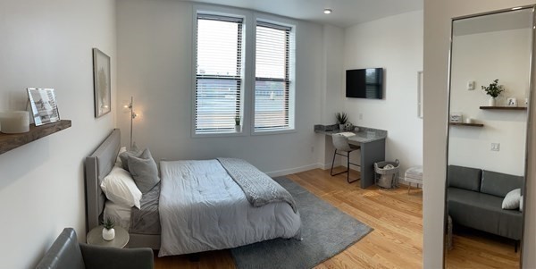 a bedroom with a bed and wooden floor