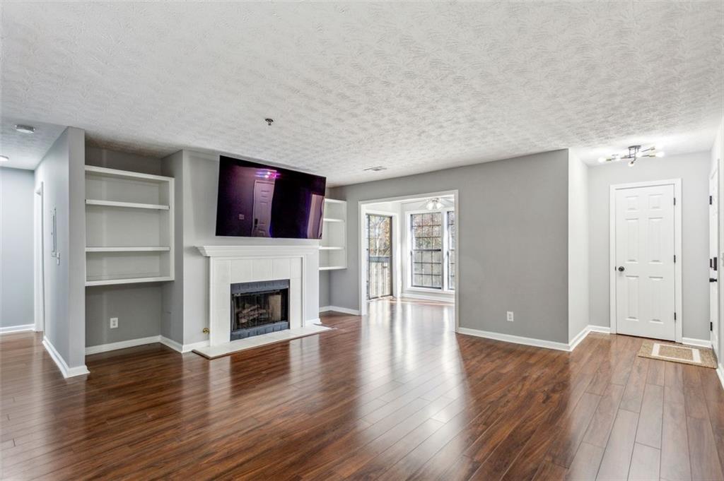 a view of a livingroom with a fireplace wooden floor and fire place