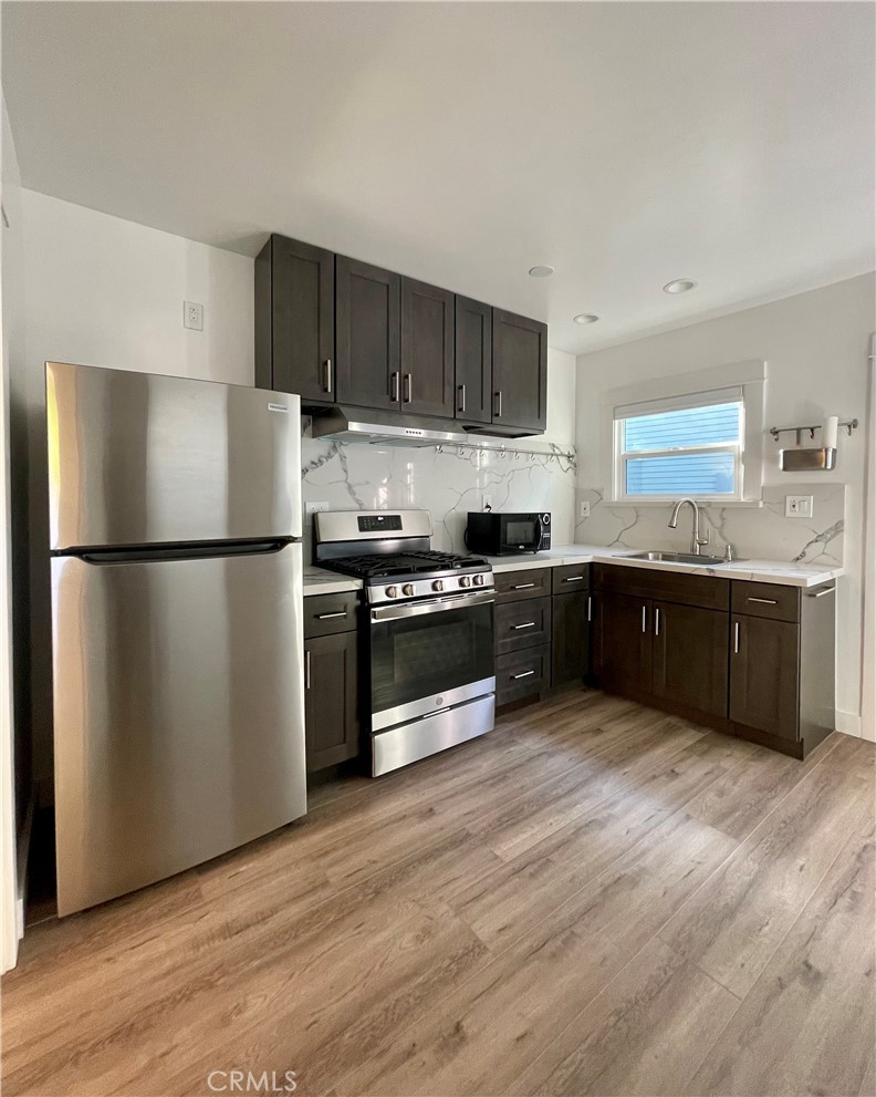 a kitchen with stainless steel appliances wooden floors and wooden cabinets