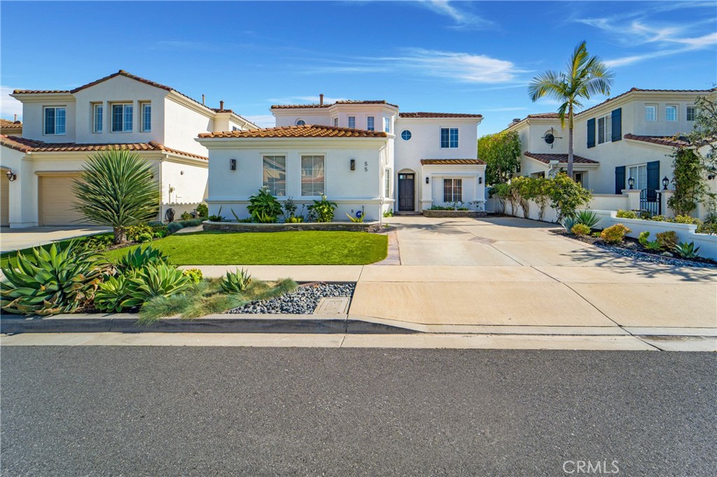 a front view of a house with a yard and potted plants