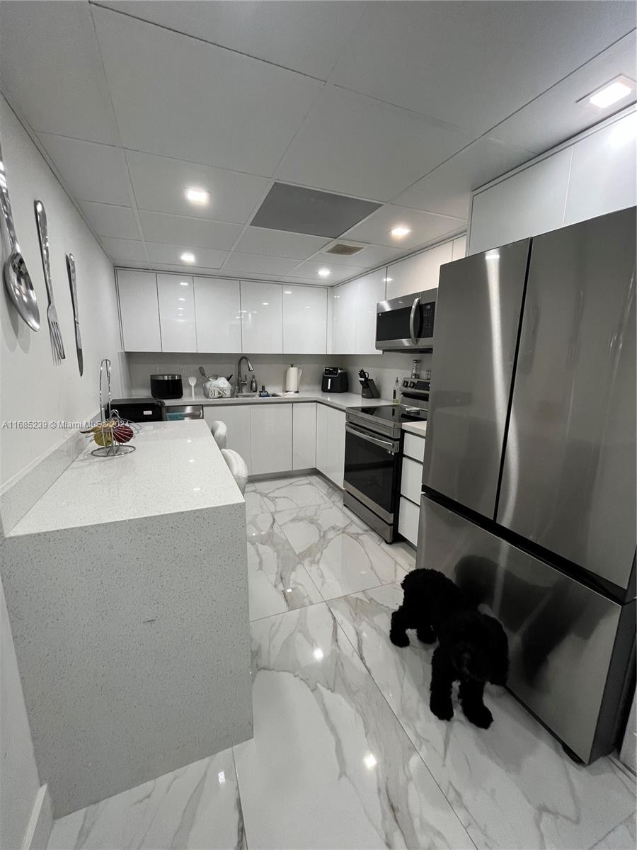 a kitchen with refrigerator and cabinets