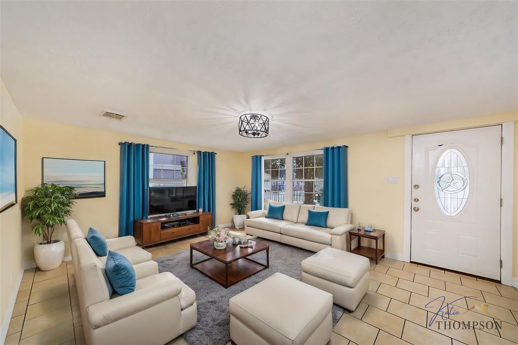 a living room with furniture a flat screen tv and a large window