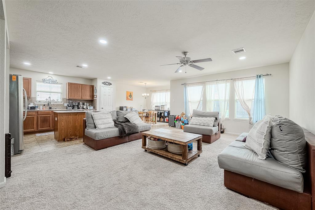 a living room with furniture and view of kitchen