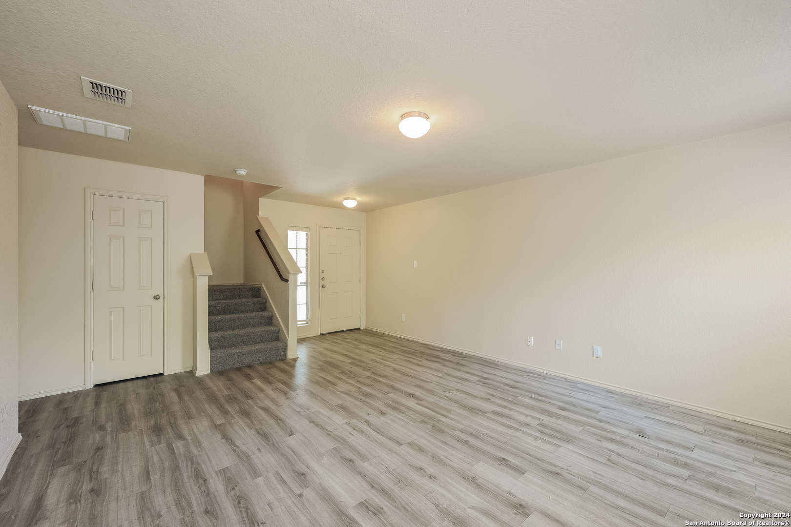 a view of empty room with wooden floor