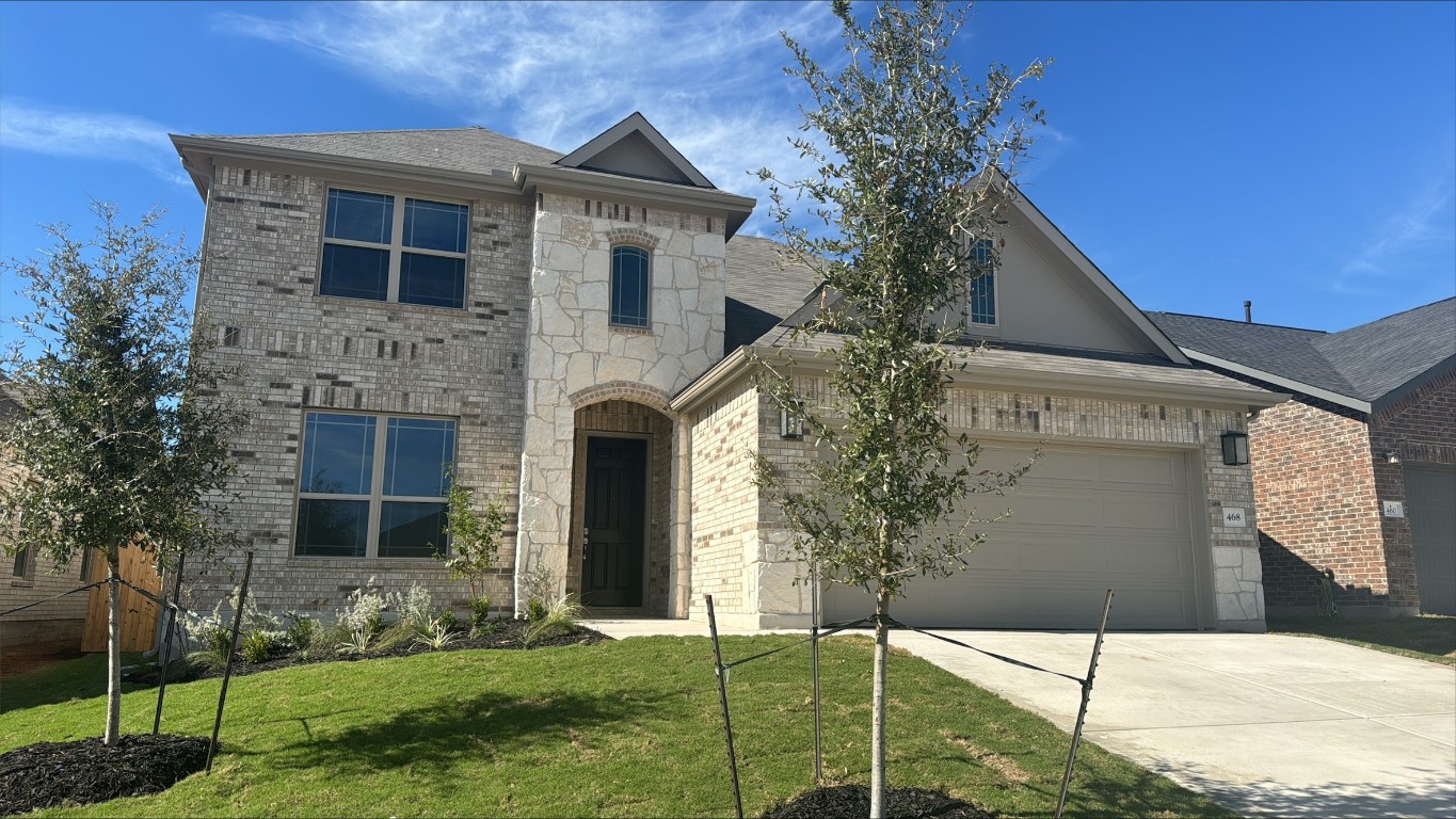 a front view of a house with a yard and garage