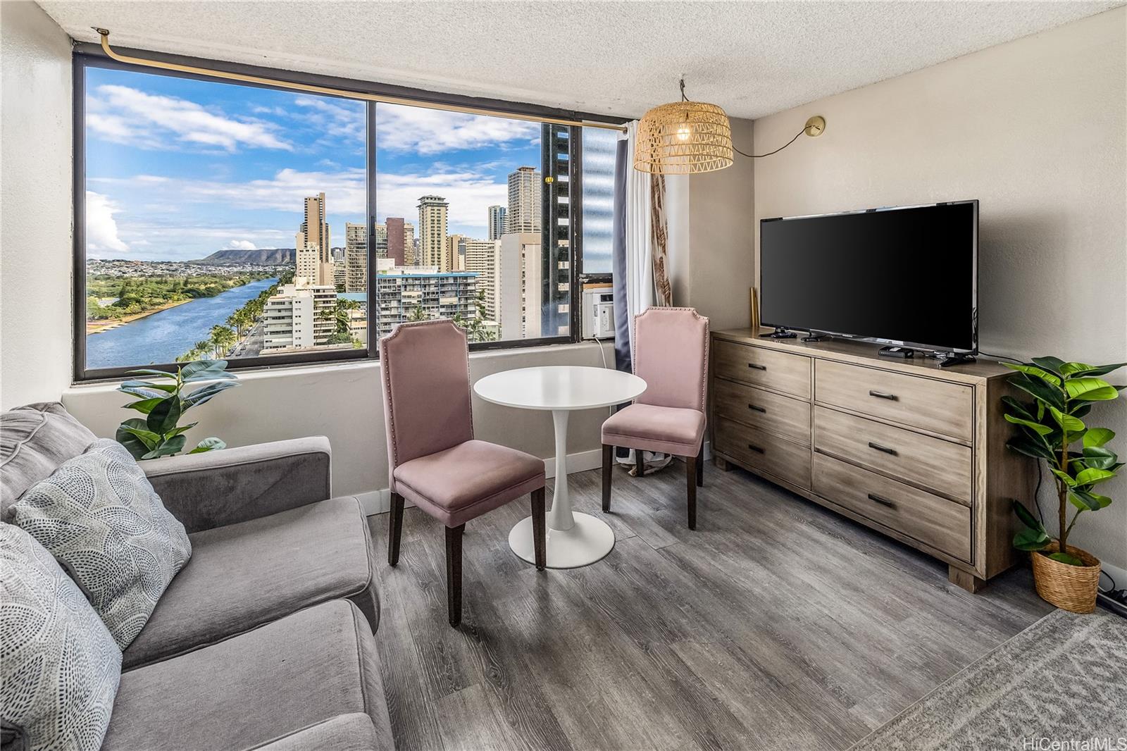 a living room with furniture a flat screen tv and a floor to ceiling window