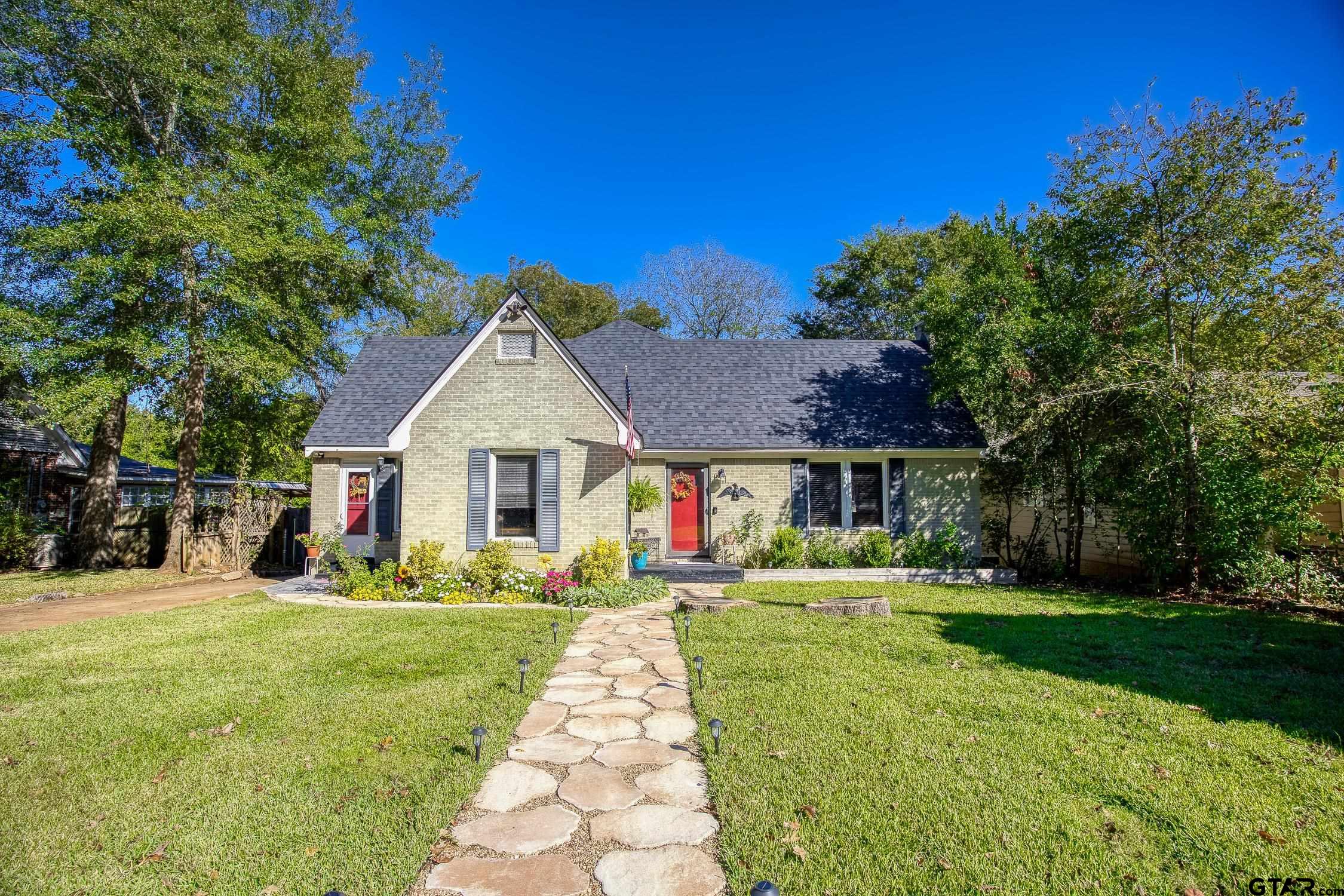 a front view of a house with a yard and trees