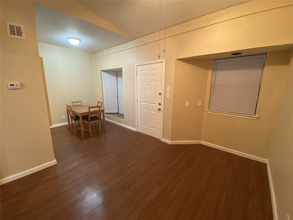 an empty room with wooden floor and furniture