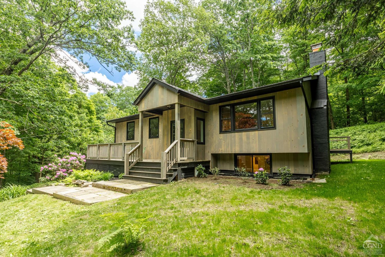 a view of a house with backyard and sitting area