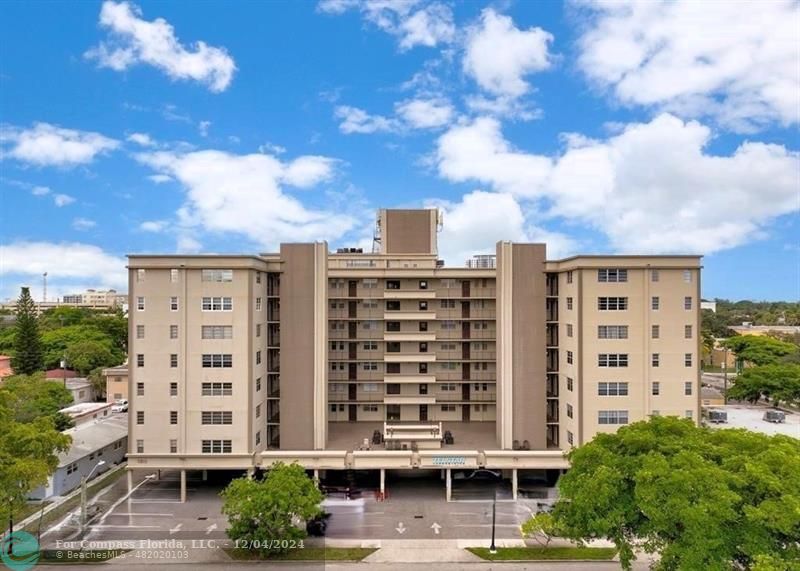 a view of a building with a lot of plants and trees