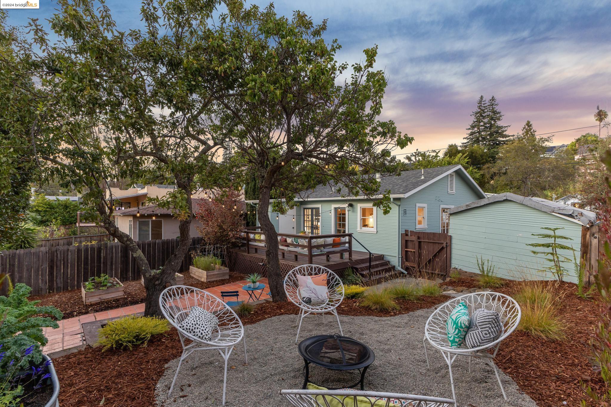 a backyard of a house with fire pit and outdoor seating