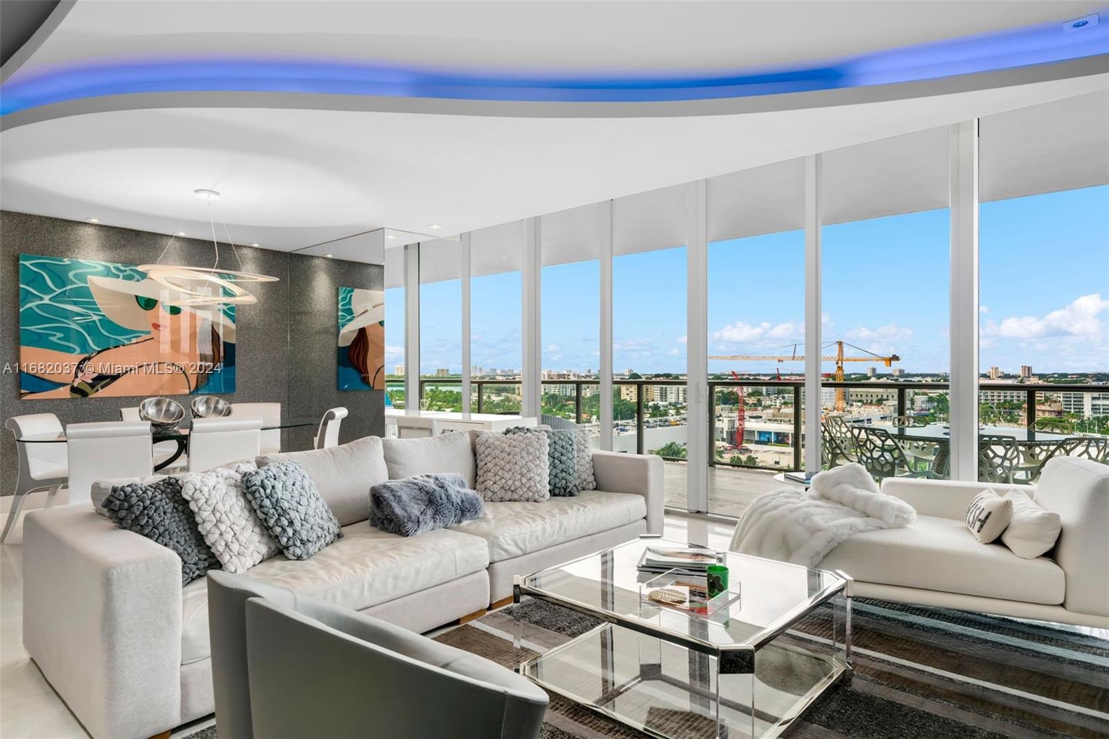 a living room with furniture kitchen view and large windows