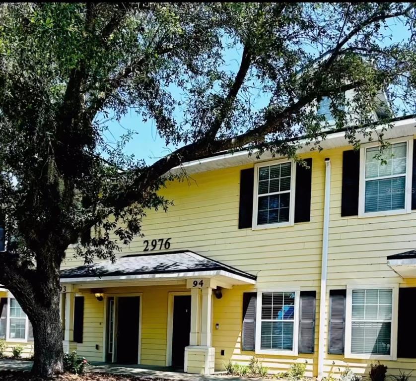 a view of a house with a large tree