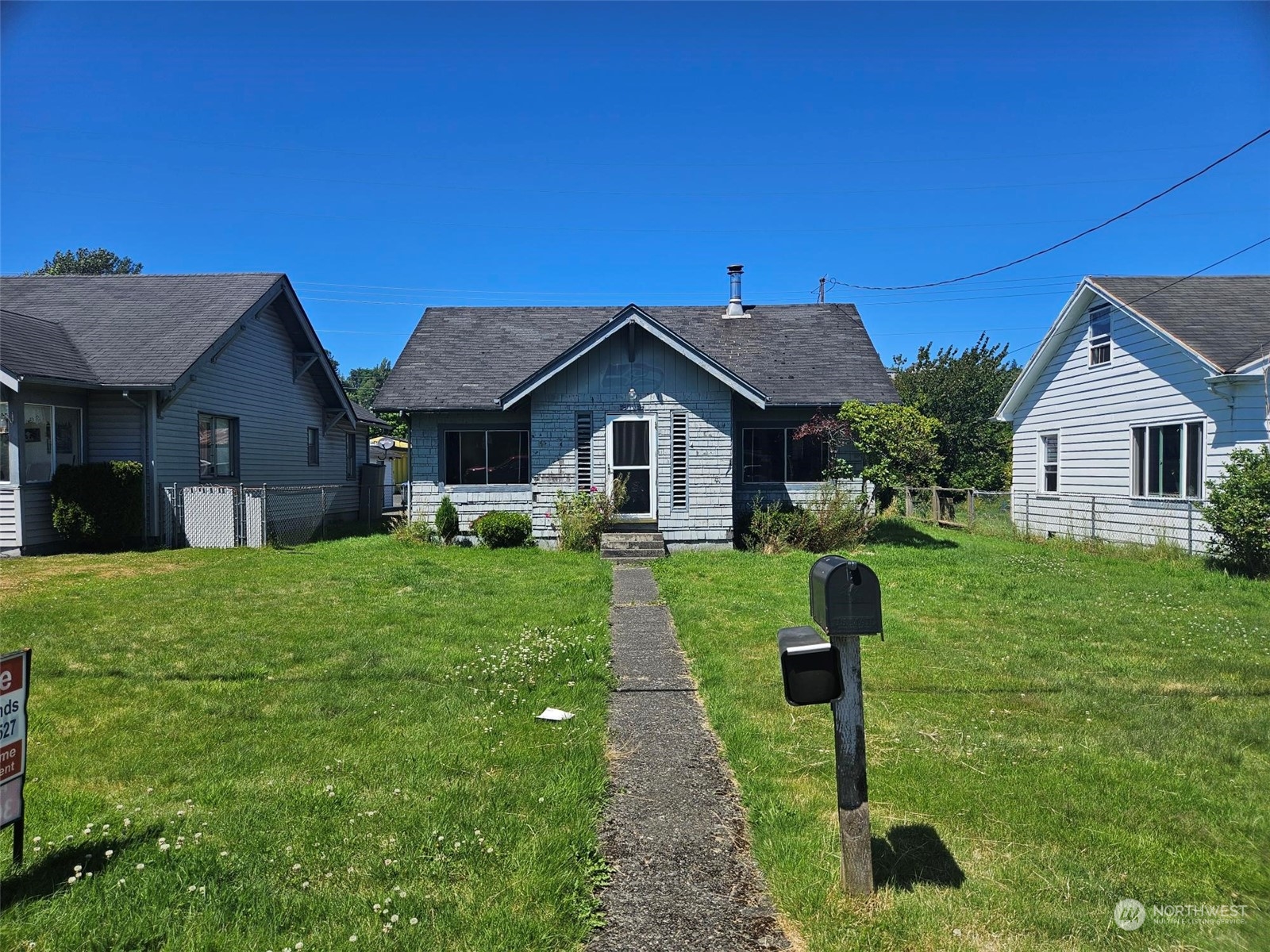 a front view of a house with a yard and tree