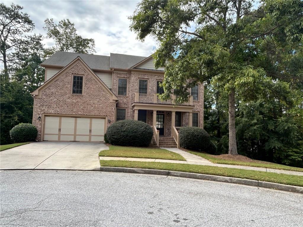 a front view of a house with a yard and trees