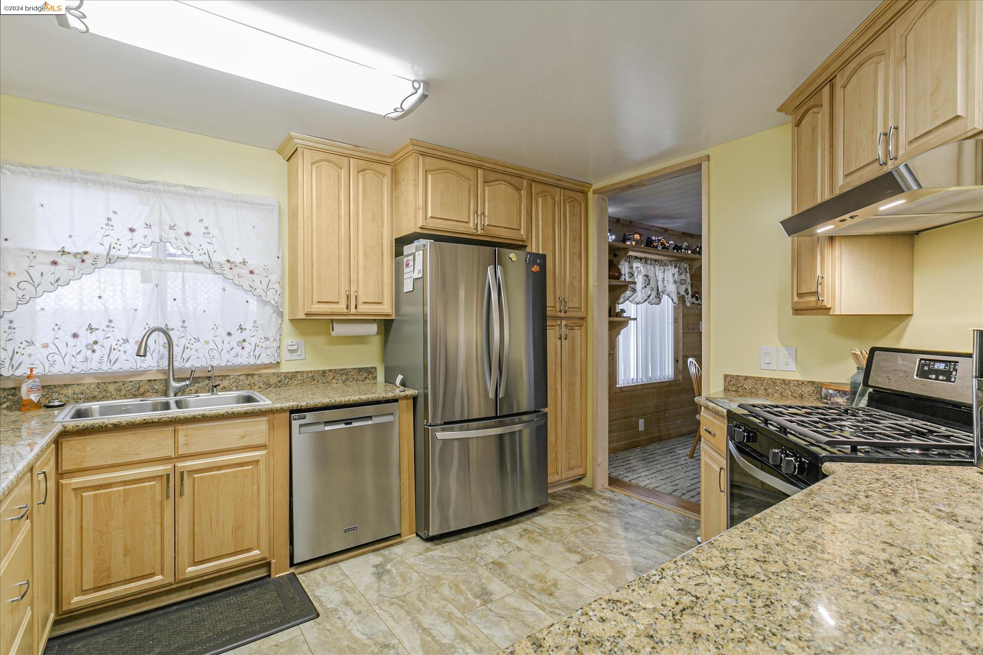 a kitchen with stainless steel appliances granite countertop a sink stove and refrigerator