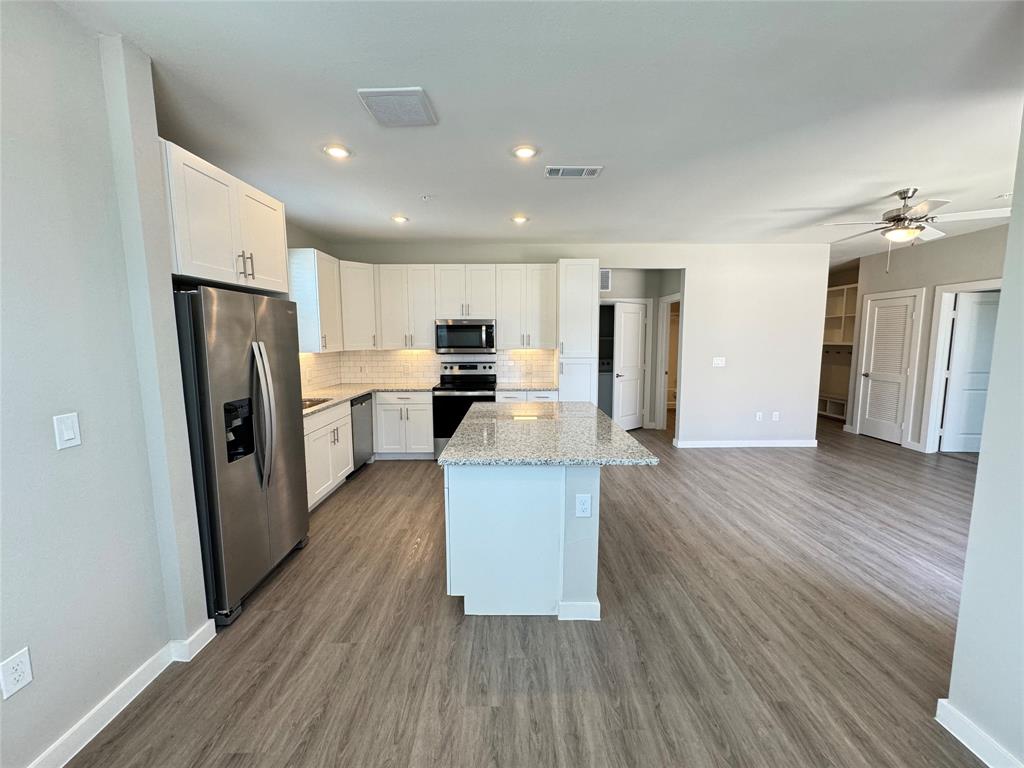 a kitchen with a refrigerator a sink and cabinets