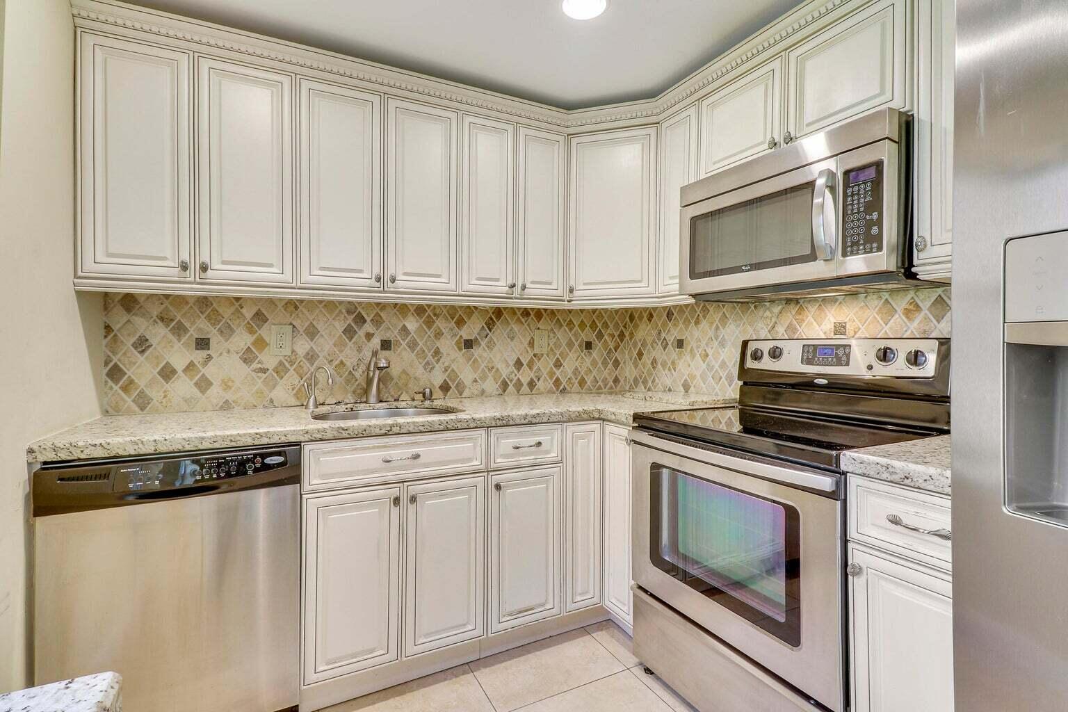 a kitchen with white cabinets and stainless steel appliances