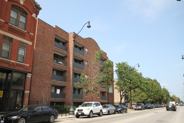 a couple of cars parked in front of brick building