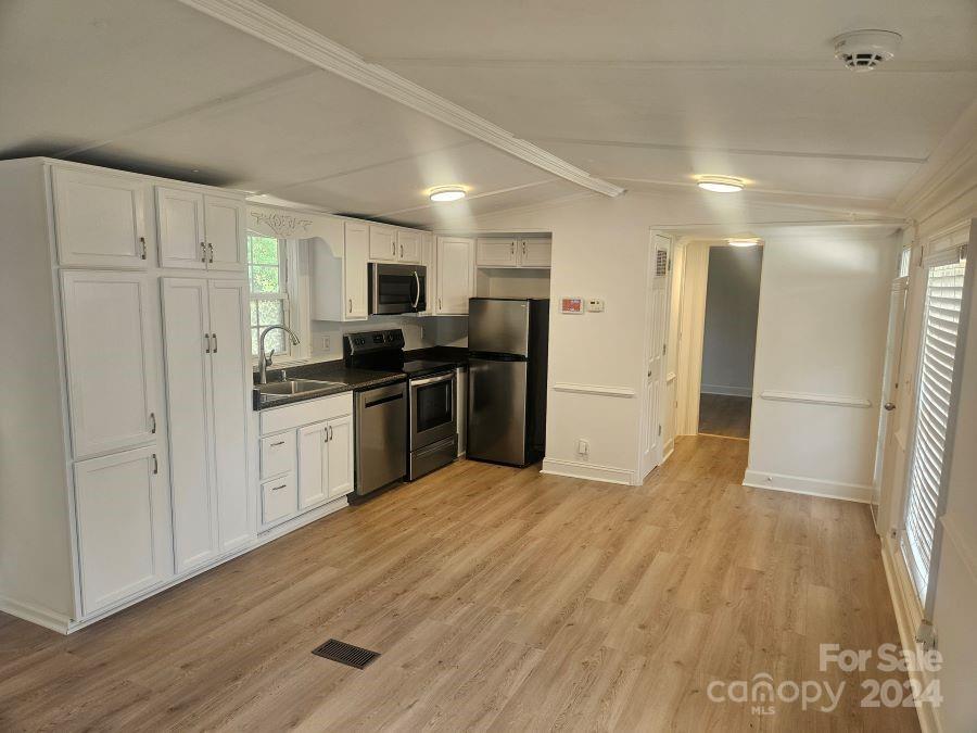 a large kitchen with cabinets and stainless steel appliances