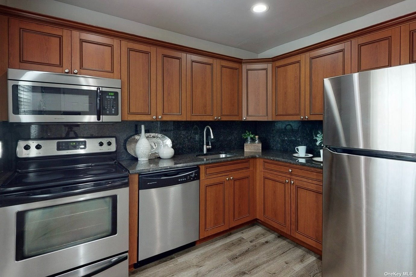 a kitchen with stainless steel appliances granite countertop a refrigerator stove and sink