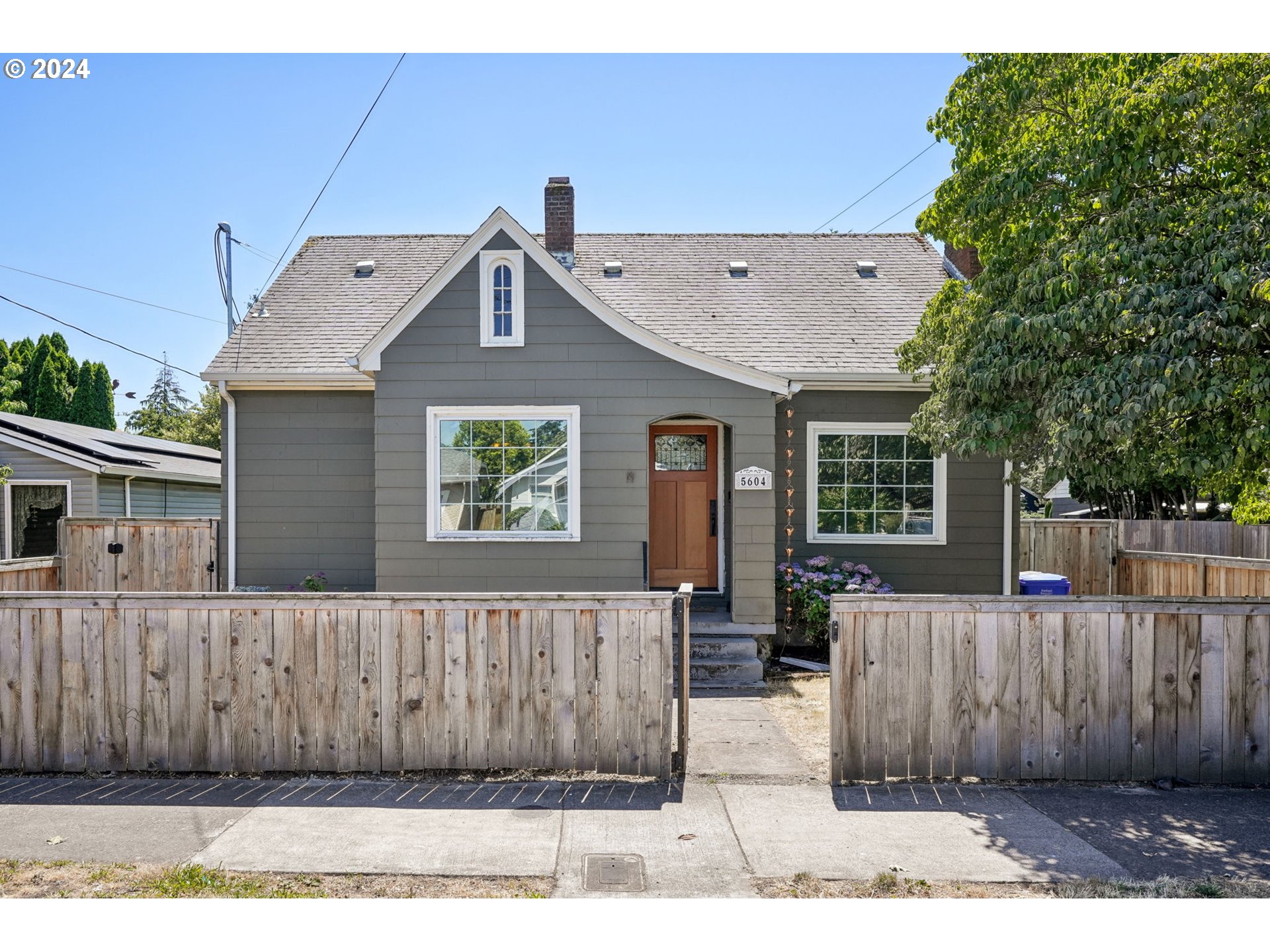 a view of a house with a wooden fence